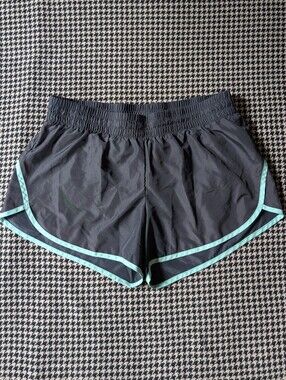Grey athletic gym shorts with teal blue accent trim and liner